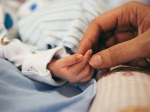 Nurse holding baby's hand